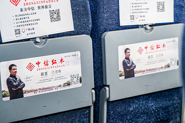 列车上的小桌板、头片、行李架、车厢广告等都融入了中信红木的品牌形象